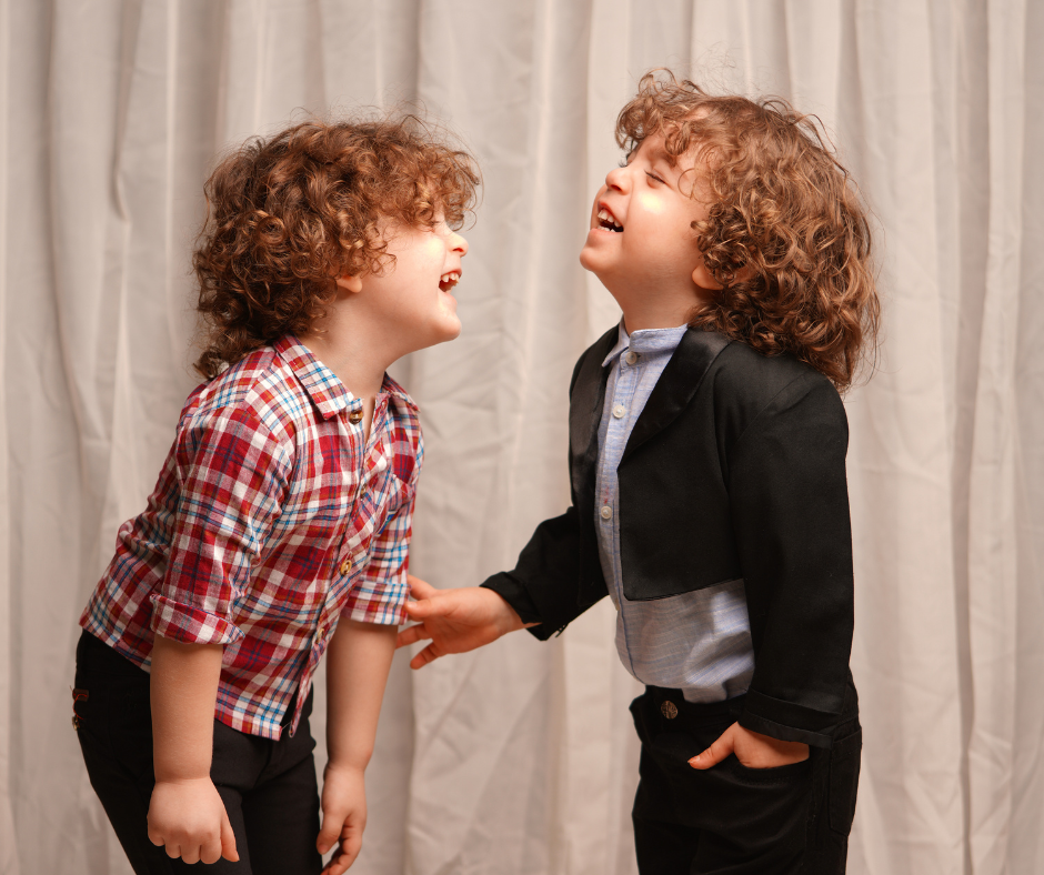 Two children laughing together in joyful play.