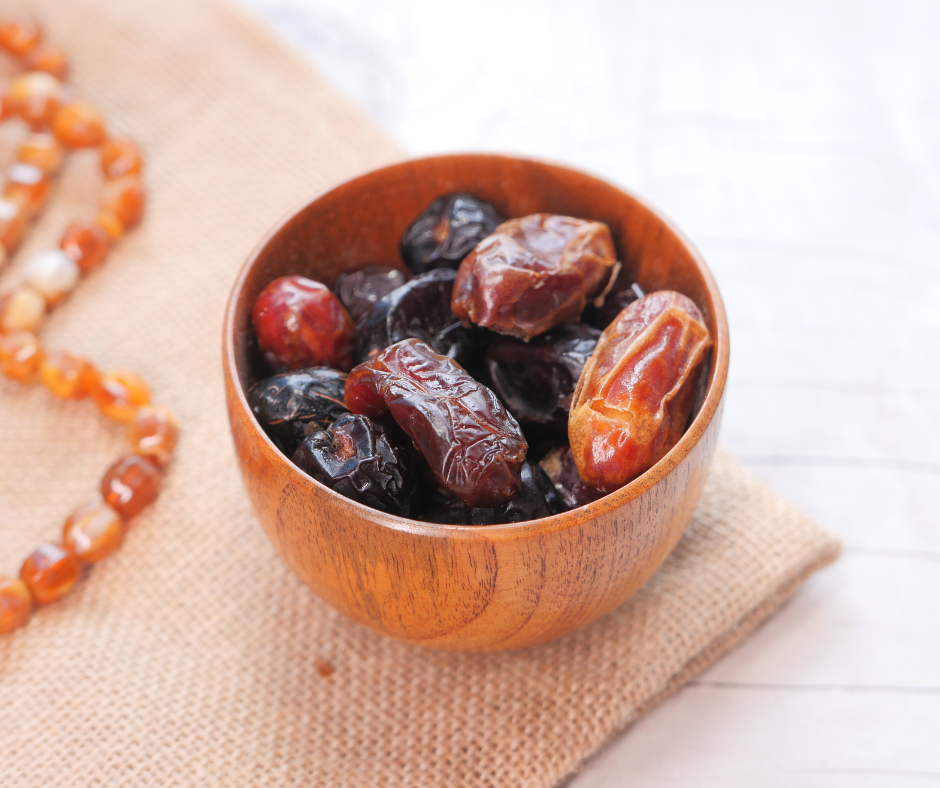 Dried dates in wooden bowl with prayer beads