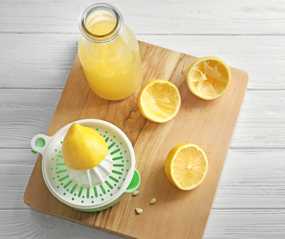 Fresh lemon juice preparation on wooden background.