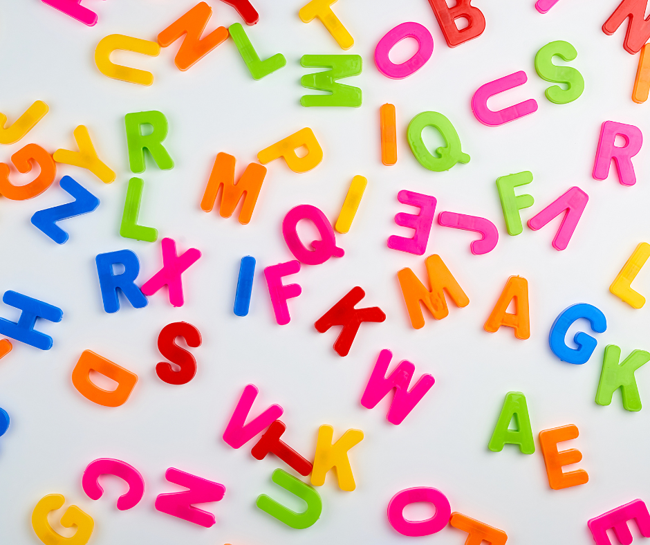 Colourful magnetic alphabet letters on white background.