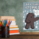 Motivational yeti poster above school supplies on desk.