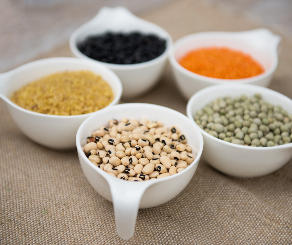 Various legumes in bowls on table.