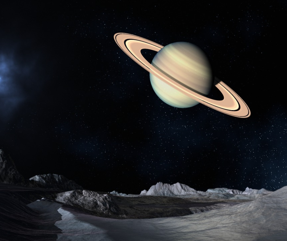 Saturn viewed from a moon's rocky surface at night.